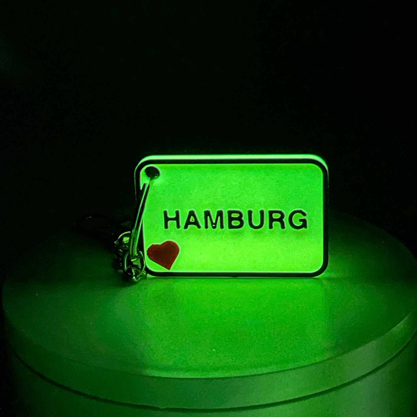NFC-Schlüsselanhänger mit Ortsschild-Design. Das gelbe Filament leuchtet bei Nacht, während die personalisierbare Vorderseite für einen individuellen Touch sorgt.